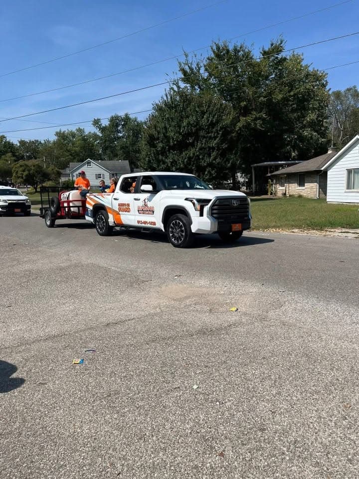 Alpha-Dog wrapped pickup parked at the curb of a residential street.
