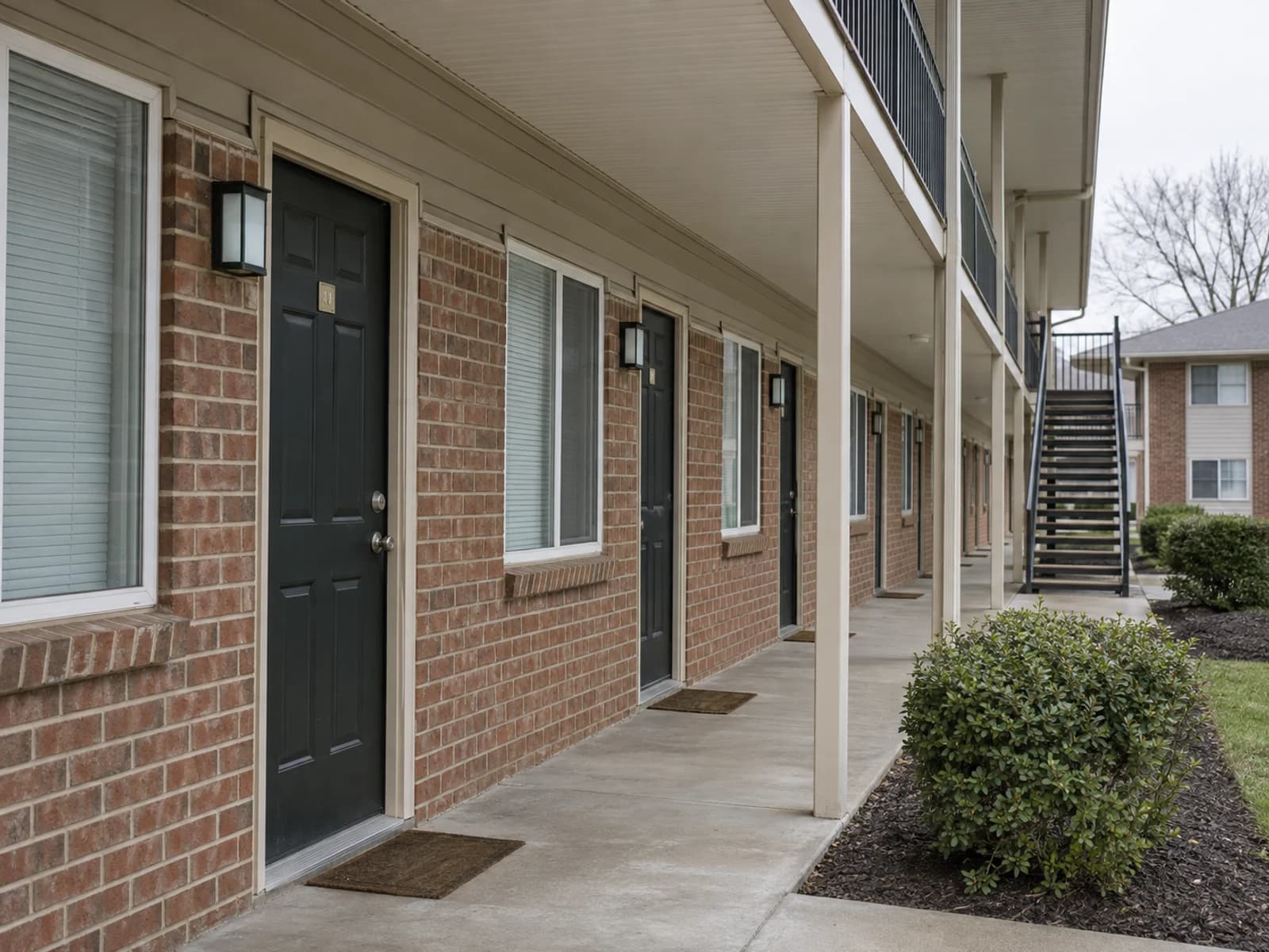 Exterior corridor and unit doors at a modest apartment building.